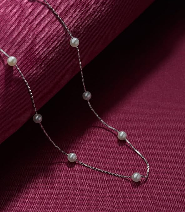 Macro shot showing the texture of 3mm freshwater pearls on a silver box chain.